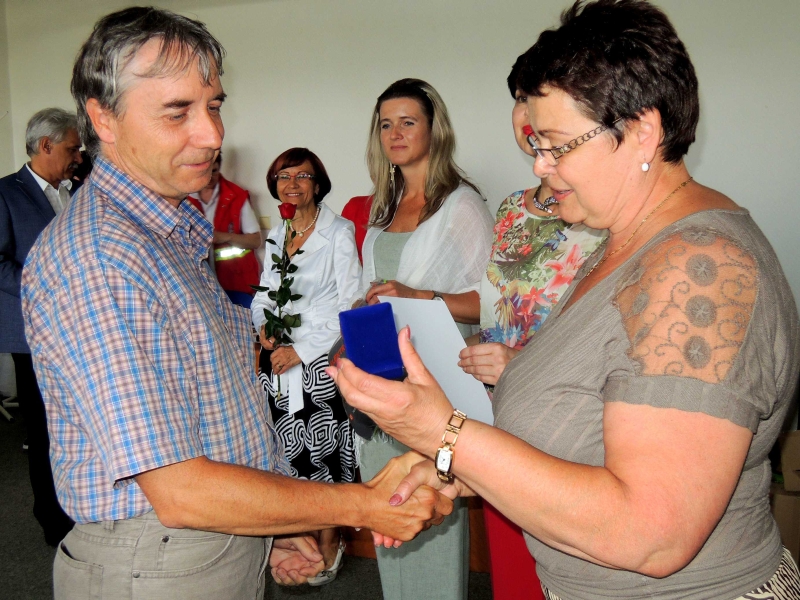 Vedoucí oblastní pobočky Českého červeného kříže Hana Fukalová předává Zlatý kříž jednomu z oceněných, panu Jiřímu Karkulíkovi.