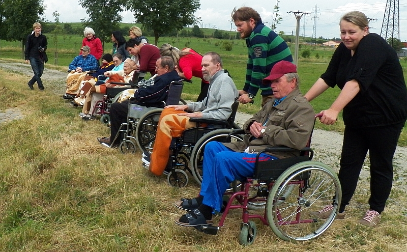 Vozíčkáři a dobrovolníci na hrázi Týnského rybníka.