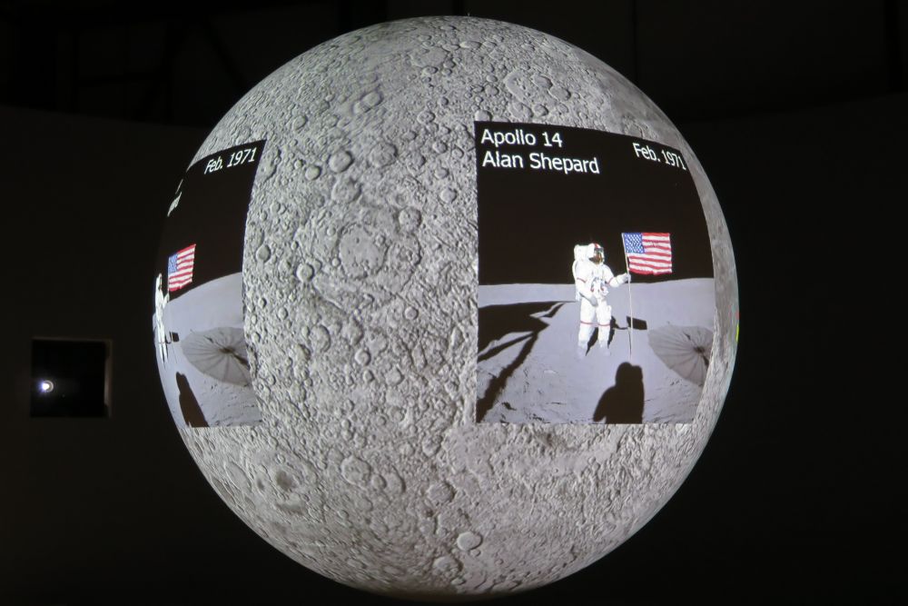 Projekce Měsíce a míst, kde přistáli astronauti.