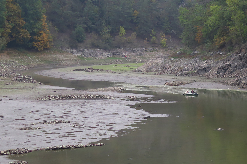 Hladina Vranovské přehrady je nyní tak nízko, že se odkryly i pozůstatky oblouků původního mostu (mírně vlevo od člunu).